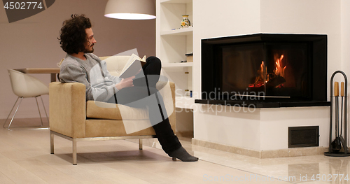 Image of young man at home reading book