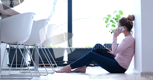 Image of young women using mobile phone on the floor