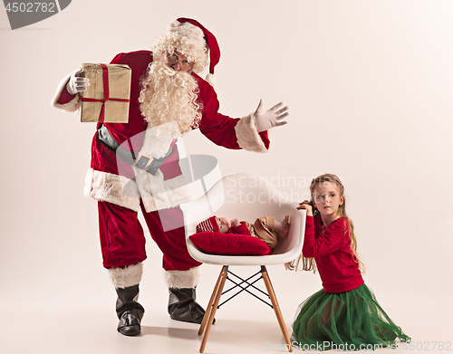 Image of Christmas portrait of cute little newborn baby girl, dressed in christmas clothes, studio shot, winter time