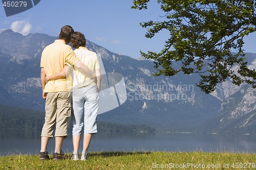 Image of Couple arm in arm at a mountain lake