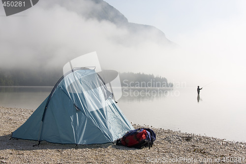 Image of Fisherman standing in a mountain lake