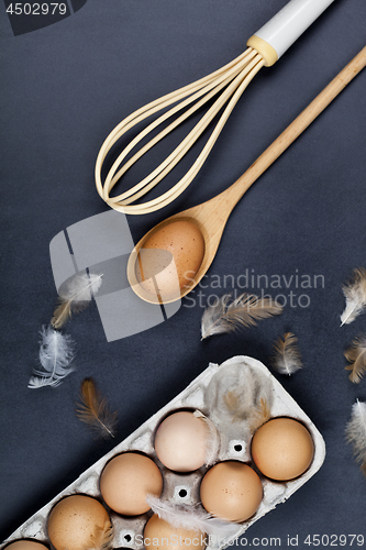 Image of Eggs, wooden spoon, whisker and feathers.