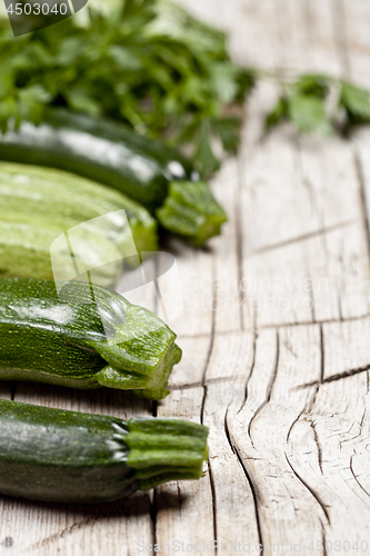 Image of Variety of green organic vegetables on rustic wooden background.