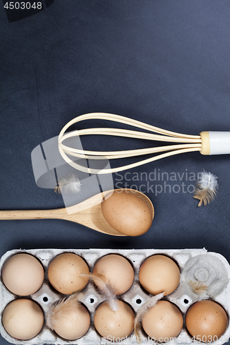 Image of Eggs, wooden spoon, whisker and feathers. 