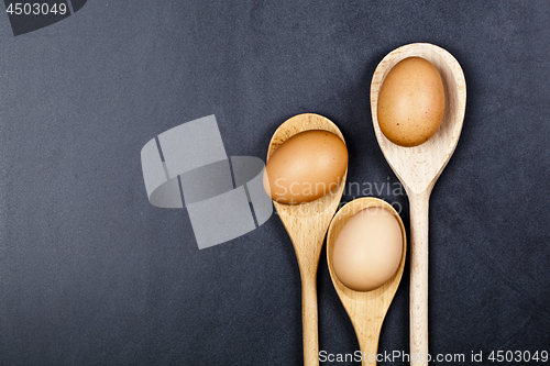 Image of Eggs in wooden spoons.