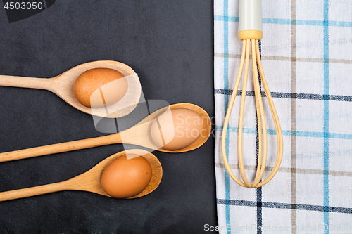 Image of Eggs and kitchen utensil on backboard background.