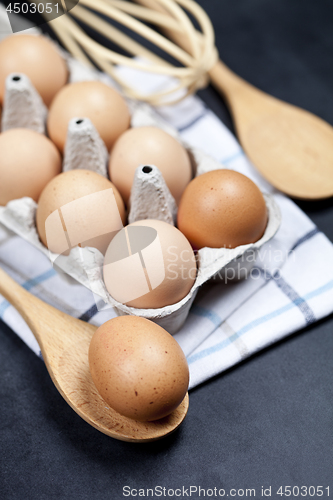 Image of Eggs and kitchen utensil closeup on backboard background.