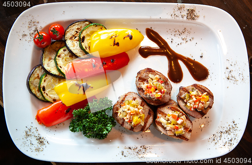 Image of a plate of meat rolls with vegetables