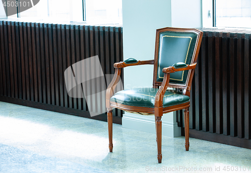 Image of chair with a leather green seat, back, and armrests
