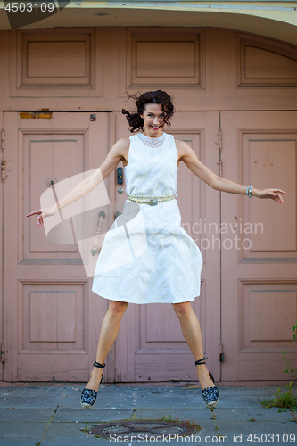 Image of woman in a white dress hovers above the ground