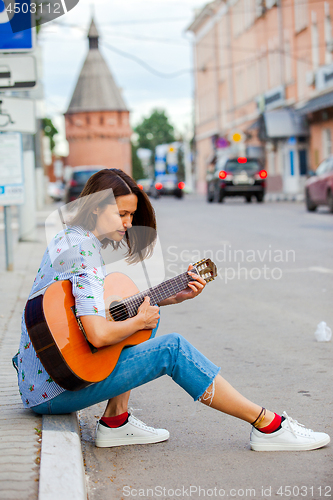 Image of beautiful european woman with guitar