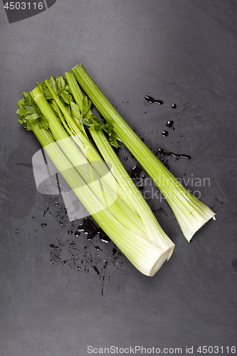 Image of Fresh green organic celery and water on black background.