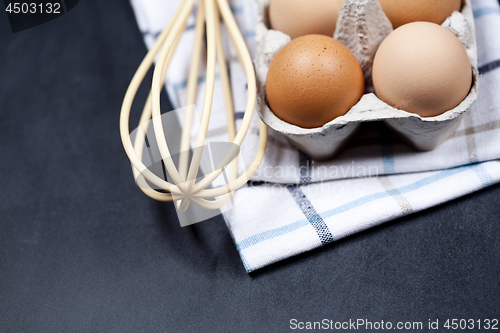 Image of Eggs in cardboard box, towel and whisker closeup on backboard ba