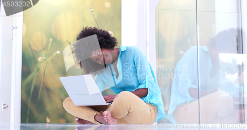 Image of black women using laptop computer on the floor