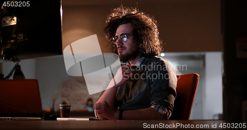 Image of man working on computer in dark office