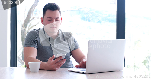 Image of businessman working using a laptop in startup office