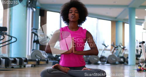 Image of back woman in a gym stretching and warming up