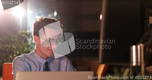 Image of man working on computer in dark office