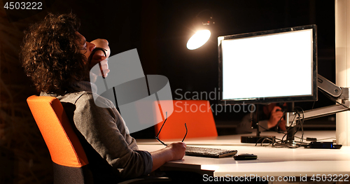 Image of man working on computer in dark office