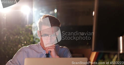 Image of man working on computer in dark office