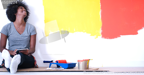 Image of black female painter sitting on floor