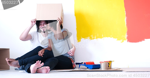 Image of young multiethnic couple playing with cardboard boxes