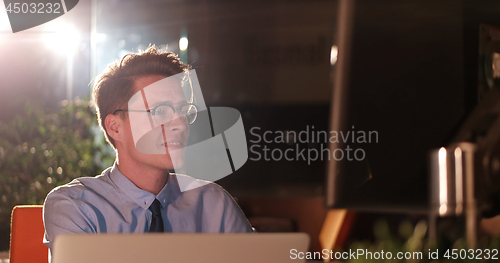 Image of man working on computer in dark office