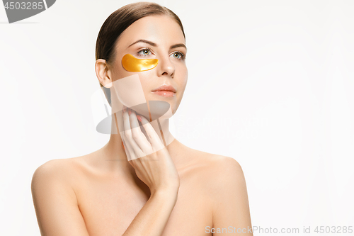 Image of Beauty portrait of an attractive girl with a gold patch under the eye.