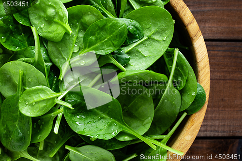 Image of Fresh spinach leaves on wooden background. Healthy vegan food. Top view