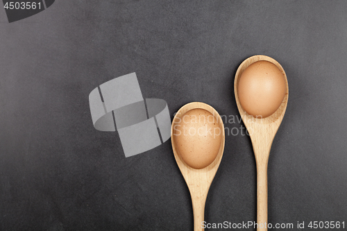 Image of Fresh chicken eggs in wooden spoons.