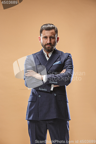 Image of Male beauty concept. Portrait of a fashionable young man with stylish haircut wearing trendy suit posing over pastel background.