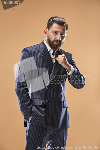 Image of Male beauty concept. Portrait of a fashionable young man with stylish haircut wearing trendy suit posing over pastel background.