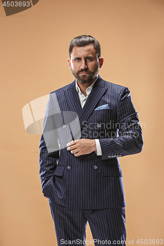 Image of Male beauty concept. Portrait of a fashionable young man with stylish haircut wearing trendy suit posing over pastel background.