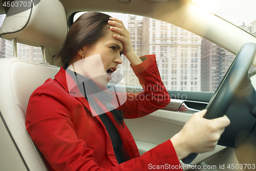 Image of Driving around city. Young attractive woman driving a car
