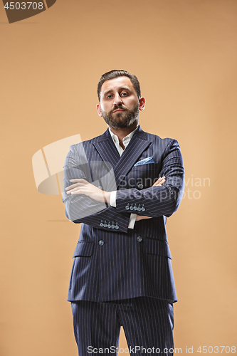 Image of Male beauty concept. Portrait of a fashionable young man with stylish haircut wearing trendy suit posing over pastel background.