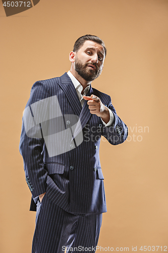 Image of Male beauty concept. Portrait of a fashionable young man with stylish haircut wearing trendy suit posing over pastel background.