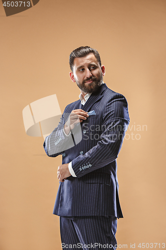 Image of Male beauty concept. Portrait of a fashionable young man with stylish haircut wearing trendy suit posing over pastel background.