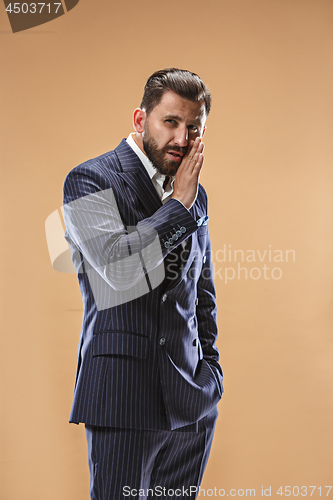 Image of The young man whispering a secret behind her hand over pastel background