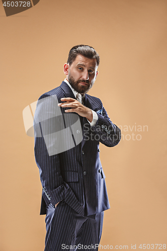 Image of Male beauty concept. Portrait of a fashionable young man with stylish haircut wearing trendy suit posing over pastel background.