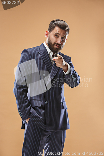 Image of Male beauty concept. Portrait of a fashionable young man with stylish haircut wearing trendy suit posing over pastel background.