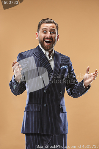 Image of The young attractive man looking suprised isolated on pastel