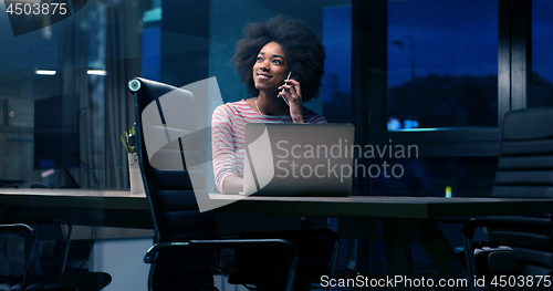 Image of black businesswoman using a laptop in night startup office