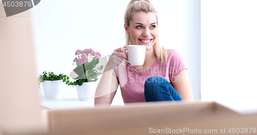 Image of woman with many cardboard boxes sitting on floor