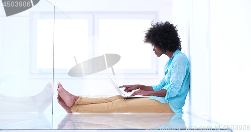 Image of black women using laptop computer on the floor