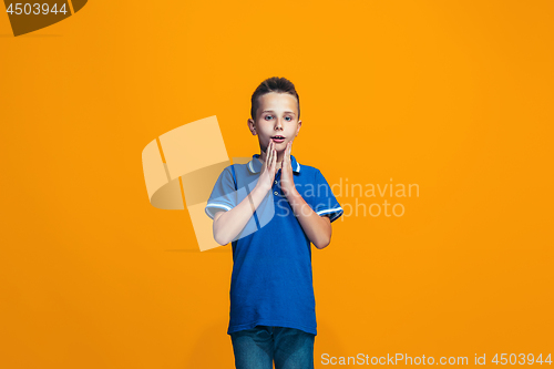 Image of Beautiful teen boyl looking suprised isolated on orange