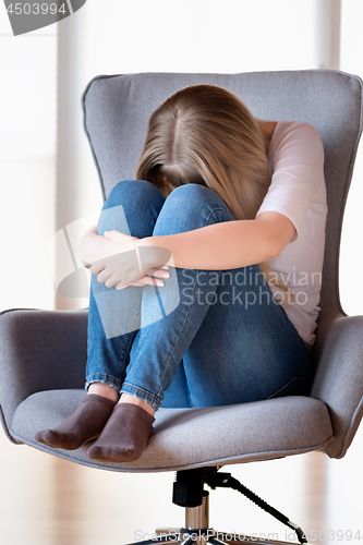 Image of Sad girl sitting on chair