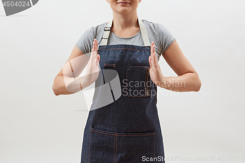 Image of Woman chef cook in a denim apron holds your empty hands open on a white background. Mock up copy space concept .