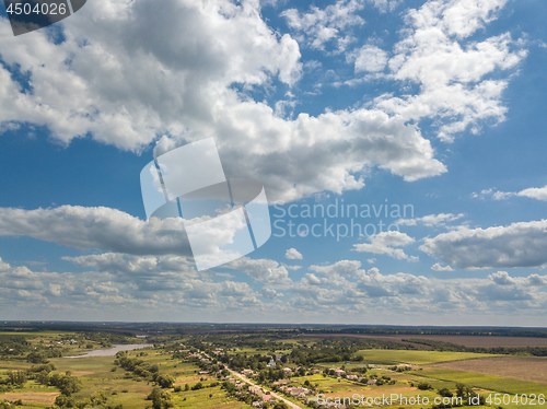 Image of Amazing landscape with fields, country and river on a background of blue cloudy sky in a summer day. Aerial view from drone.