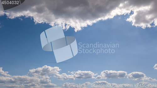 Image of Natural frame from white clouds on a background of blue sky with sunbeams. Copy space.