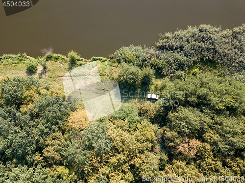 Image of Aerial view from drone recreation place on a bank of river. Top view green trees, meadow and white car. Top view.